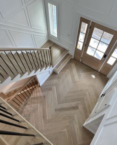 an overhead view of a staircase with wood floors and white painted walls in a home