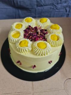 a white cake with yellow and purple decorations