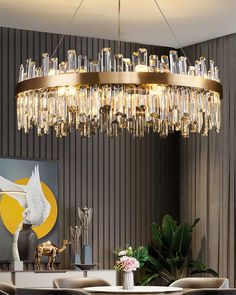 a modern chandelier hangs above a dining room table with chairs and vases