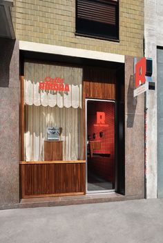 an open door to a store with curtains on the windows