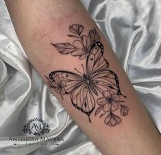 a black and white butterfly tattoo on the arm