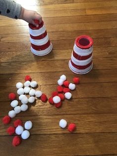 the child is playing with red and white candies on the floor next to two stacks of candy