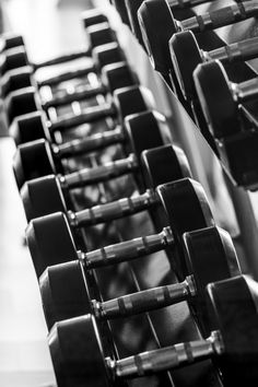 black and white photograph of rows of dumbbells