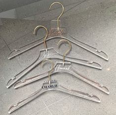 a set of five clear plastic hangers with gold colored metal clips on each one