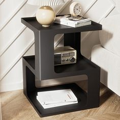 an end table with a radio and books on it