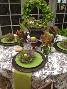 the table is set with green plates and place settings for an easter dinner or brunch