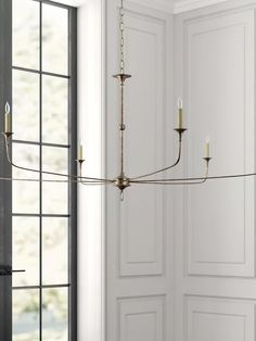 a chandelier hanging from the ceiling in a room with white walls and doors