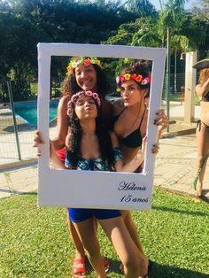 three women in bikinis holding up a photo frame