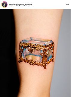 a woman's arm with a tattoo on it that looks like an old jewelry box