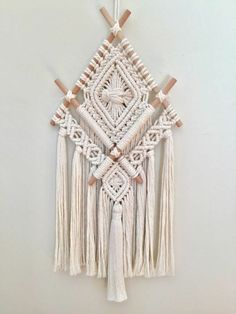 a white wall hanging with tassels on it