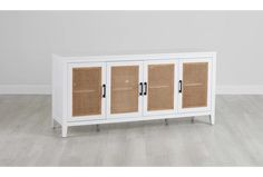 a white cabinet with wicker doors on the front and bottom, against a wall