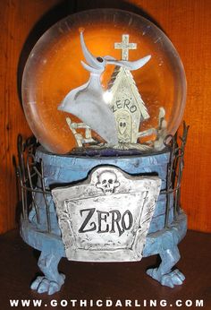 a snow globe sitting on top of a wooden table next to a cross and tombstone