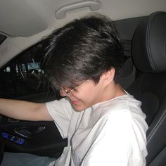 a young man sitting in the passenger seat of a car