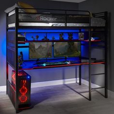 a computer desk with a gaming keyboard and monitor on it, in front of a blue light