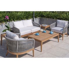 an outdoor patio furniture set with white cushions