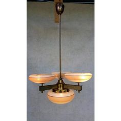 a chandelier with five lights hanging from it's sides on a wall