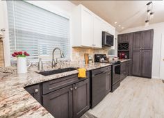 a kitchen with granite counter tops and white cabinets