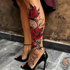 a woman's legs with red flowers and swirls on the leg, while she is wearing high heels