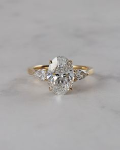 an oval diamond ring with three pear shaped diamonds