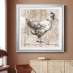 a chicken is hanging on the wall next to a chair and sideboard in a living room