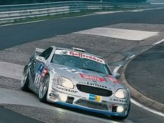 a silver car driving down a race track