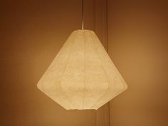 a white lamp hanging from a ceiling in a room with brown walls and flooring