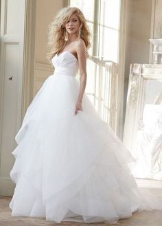 a woman in a wedding dress posing for the camera