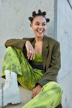 Stock Image: Positive carefree teenage girl with bun hairstyle looks happily away wears stylish green costume and white boots blue eyeliner feels good poses against grey concrete wall. Urban lifestyle concept Grey Concrete Wall, Bold Clothing, Green Costume, Green Costumes, Blue Eyeliner, Fashion Stand, Bun Hairstyle, Fashion Statements, Hairstyle Look