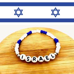 Show your support for Israel with this beautiful bracelet, which showcases the striking blue and white colors of the national flag of Israel. Wear it proudly to stand in solidarity with this incredible nation.Made with small seed beads and stretch cord material to allow for flexibility in size, this bracelet not only adds a touch of style to your ensemble but also proudly expresses your solidarity with Israel. It also makes a perfect gift for friends and family who share your support.Note: A por Blue And White Jewelry, Word Bracelet, Jewish Jewelry, Hanukkah Gifts, White Jewelry, White Colors, National Flag, Heart Jewelry, Beautiful Bracelet