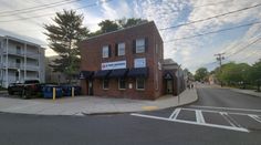 an empty street in front of two brick buildings