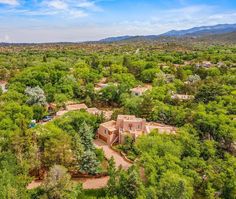 an aerial view of a home surrounded by trees in the middle of a wooded area