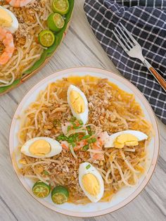 two plates of noodles with shrimp and boiled eggs