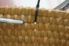 a pen sitting on top of a wooden basket