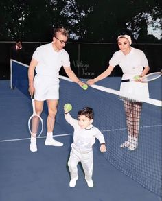 a man and woman holding hands over a tennis net with a small child on the other side