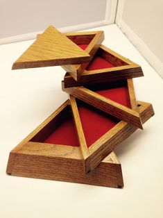 three wooden boxes are stacked on top of each other with red velvet in the bottom