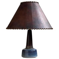 a table lamp with a brown shade on it's base and a blue base