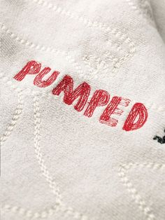 an embroidered sweater with the word pamped on it's chest and red writing