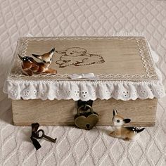 two little deer figurines sitting on top of a wooden box next to keys