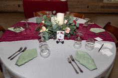 the table is set with silverware and place settings