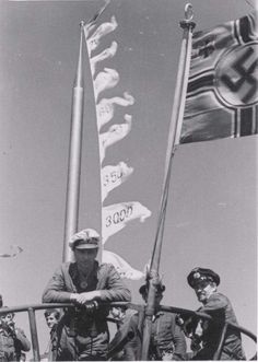 black and white photograph of men in uniform holding flags