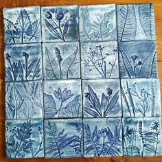 blue and white tiles with plants on them are arranged in the shape of rectangles