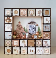 a wooden frame with christmas decorations and pictures on the front is decorated in brown, white and gold