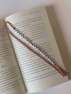 an open book with two bracelets on it's pages and the words love spelled in small letters