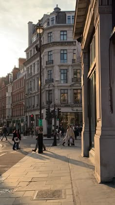 people are walking on the sidewalk in front of buildings