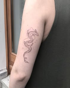 a woman with a dragon tattoo on her left arm and right arm behind her back