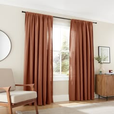 a living room with a couch, chair and window covered in orange drapes