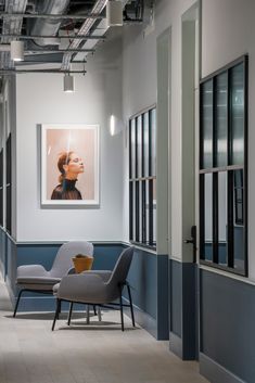 an empty room with chairs and paintings on the walls