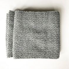 two pieces of gray and white knitted fabric on top of each other, one folded in half