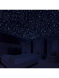 a bedroom with stars on the ceiling, and a bed in the foreground is lit up by blue lights