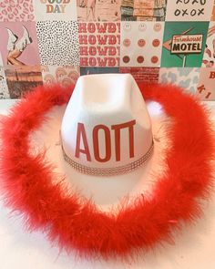 a white hat with red fur around the brim and words aot on it